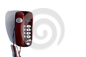 Burgundy landline phone stands on a white background