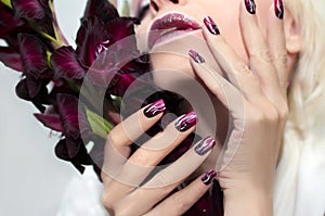 Burgundy manicure with gladiolus.