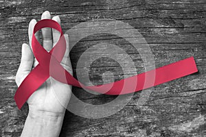 Burgundy ribbon awareness symbolic concept for multiple myeloma cancer and Sickle-Cell Anemia on person`s hand support photo