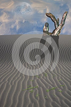 Buried sculpture of hand in desert