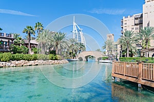 Burj Al Arab Jumeirah Island or boat building with turquoise lake or river and reflection, Dubai Downtown skyline, United Arab