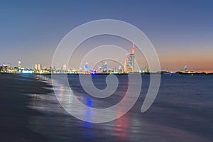 Burj Al Arab in Jumeirah Island or boat building with waves on sea beach, Dubai Downtown skyline, United Arab Emirates or UAE.