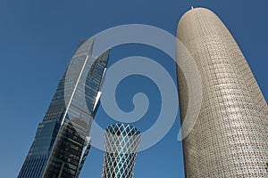 Burj Doha (Burj Qatar, Doha Tower), QIPCO Tower and Palm Tower against clear blue sky, close up view