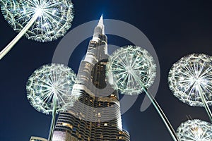 Burj Khalifa in the night against of luminous dandelions.