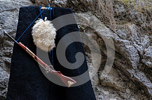 Burka cap and gun on a background of mountains