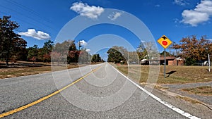 POV driving country road blue sky fall season stop sign warning