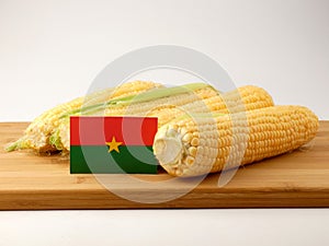 Burkina Faso flag on a wooden panel with corn isolated on a whit
