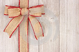 Burlap Christmas bow and ribbon side border on old white wood