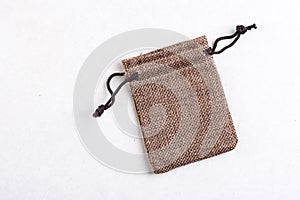 Burlap jute drawstring gift jewelry pouches bag isolated above white marble stone