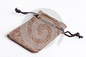 Burlap jute drawstring gift jewelry pouches bag isolated above white marble stone