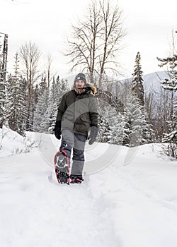 Burly Outdoorsman Snoeshoeing in the Forest