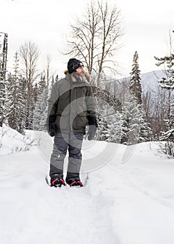 Burly Outdoorsman Snoeshoeing in the Forest