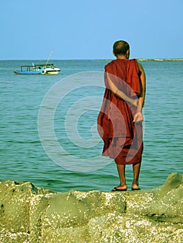 Burma. Monk Standing on Rock