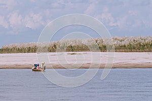 Burmese fishing boat on the River with Grass tree background