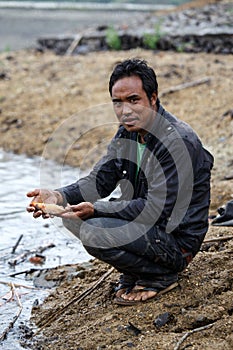 Burmese man holding freshwater fish