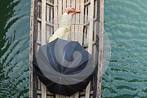 Burmese man sleeping in a boat covered with black umbrella on Inle lake, Myanmar