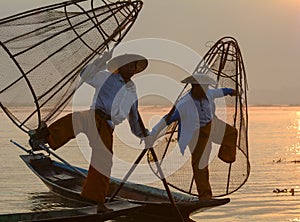 Burmese men catching fish on lake in Inle, Myanmar