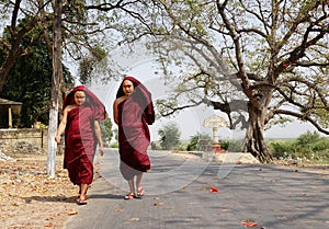 Burmese monks walking on street at Mingun village in Mandalay, Myanmar