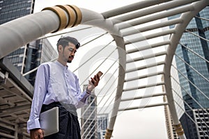 Burmese Myanmar man using smartphone in modern city