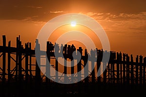 People crossing the longest teak bridge in the world, the iconic wooden U Bein Bridge during sunset, Mandalay, Myanmar