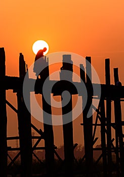 People crossing the longest teak bridge in the world, the iconic wooden U Bein Bridge during sunset, Mandalay, Myanmar