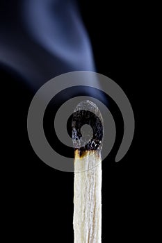 Burn-out match with smoke black background