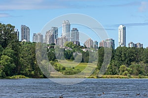 Burnaby, British Columbia, Canada skyline from Deer Lake looking towards Metrotown and apartment complexes on a sunny summer day