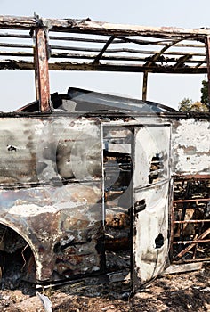 Burned bus at the side of the road, door