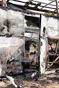 Burned bus at the side of the road, door