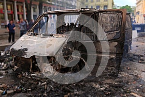 Burned car in the center of city after unrest