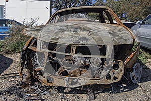 Burned car, destroyed vehicle after a fire melted is on the street