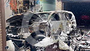 A burned car after a missile strike in the courtyard of a residential building. Russian-Ukrainian war.