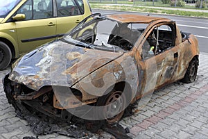 Burned car parked on the street after a fire.