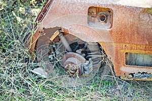 Burned car with parts burnt and grass around it