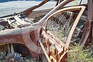 Burned car with wheels and body rusted