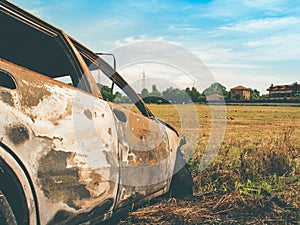 Burned car in a wild field