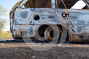 Burned down car, abstract background, selective focus. The situation of protests in the world