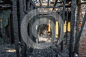 Burned down wooden apartment house, charred walls, burnt roof