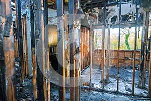 Burned house interior after fire burnt black timber roof structure building room inside