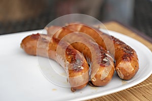 Burned Juicy sausage barbecue Sizzle on with Salt and Black Peppers on White Plate for Lunch BBQ Grilled for Picnic