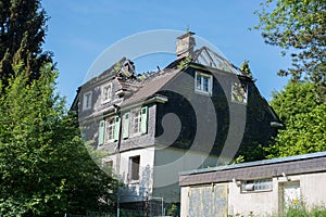 Burned out house with dilapidated roof structure with charred roof beams