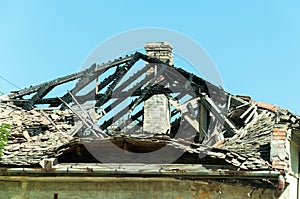 Burned roof of abandoned civilian house in Eastern Ukraine damaged by grenade explosion in the war zone.