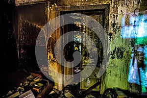 Burned room interior in apartment house. Burned door and charred walls