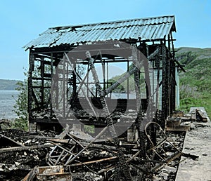 Burned village house. Burned down house, remnants of burned down, destroyed house