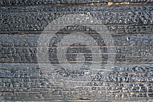 Burned wooden charred log house texture. closeup