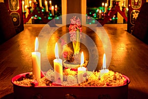 Burning Advent candles, red candlestick, oak table, close view Christmas Eve. Traditional decoration in Swedish house with window