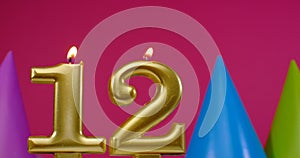 Burning birthday cake candle number 12. Happy Birthday background anniversary celebration concept. Birthday hat in the