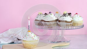 Burning birthday candle on cup cake served for birthday party on the table