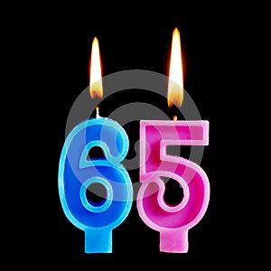 Burning birthday candles in the form of 65 sixty ive figures for cake isolated on black background. The concept of celebrating a b