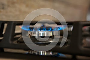 Burning blue gas on the dark stove. Burner gas stove, concept of energy. Closeup, selective focus